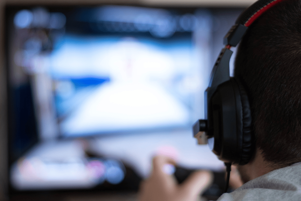 a young person in a headset plays a nondescript video game
